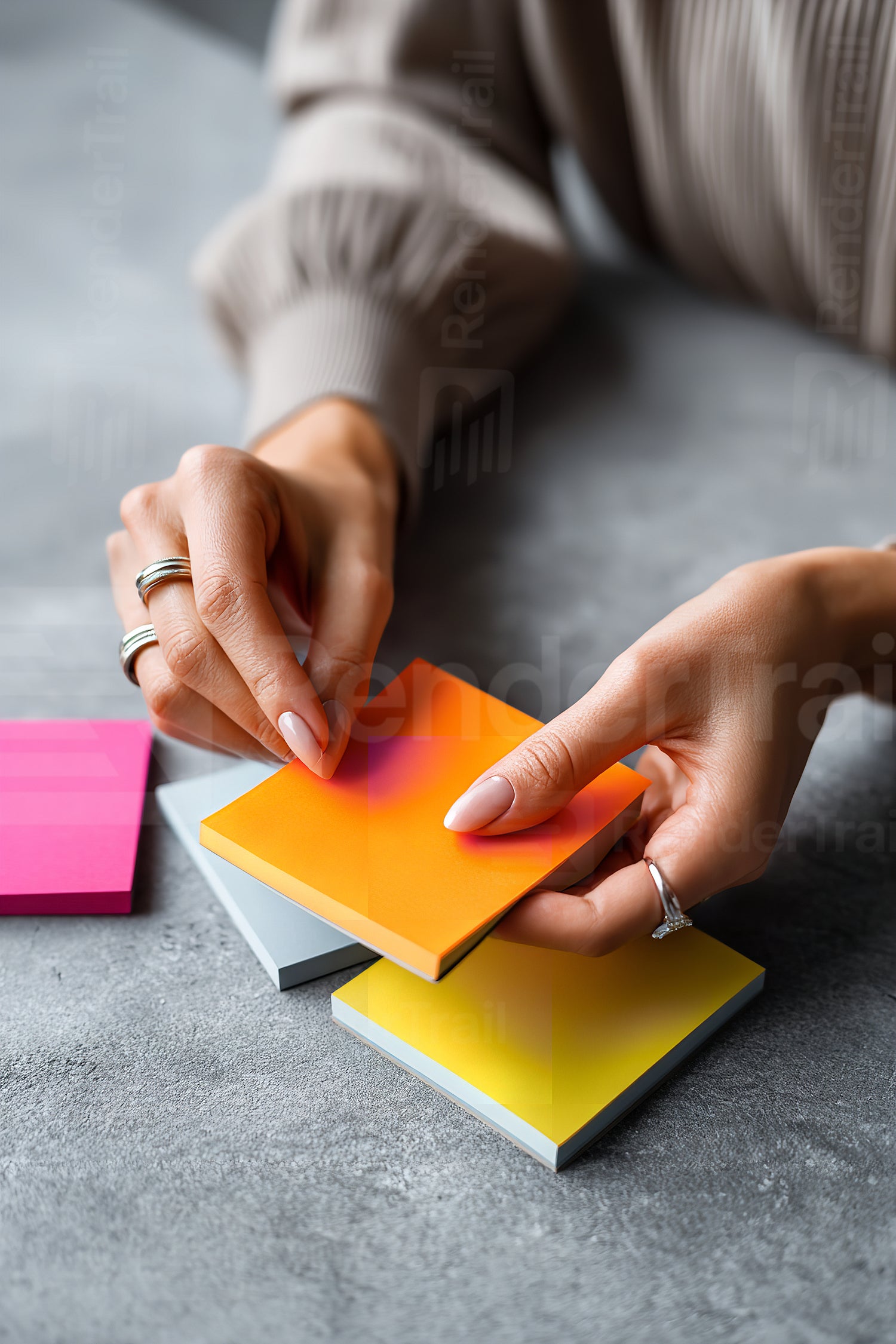Hands organizing colorful sticky notes on a gray desk in a bright workspace during the afternoon
